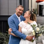 Bruidsparen met bloemen in handen.