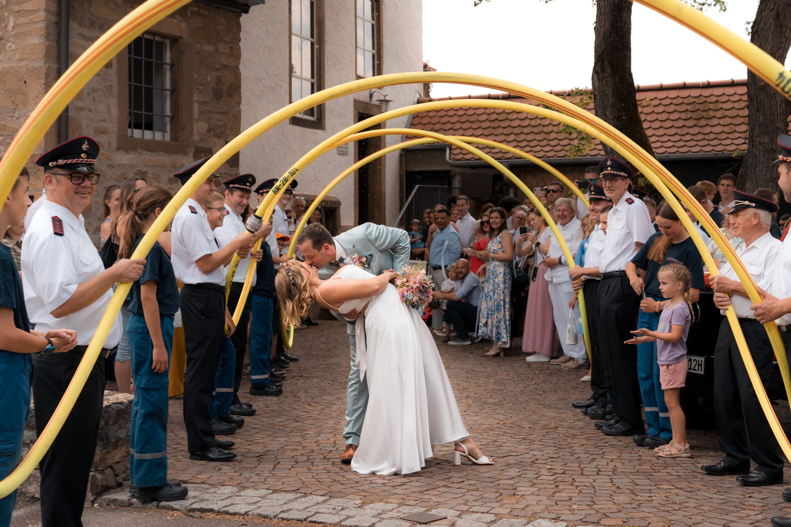 Julia und Tom beim Feuerwehr-Spalier nach ihrer Hochzeit in Neckarsulm