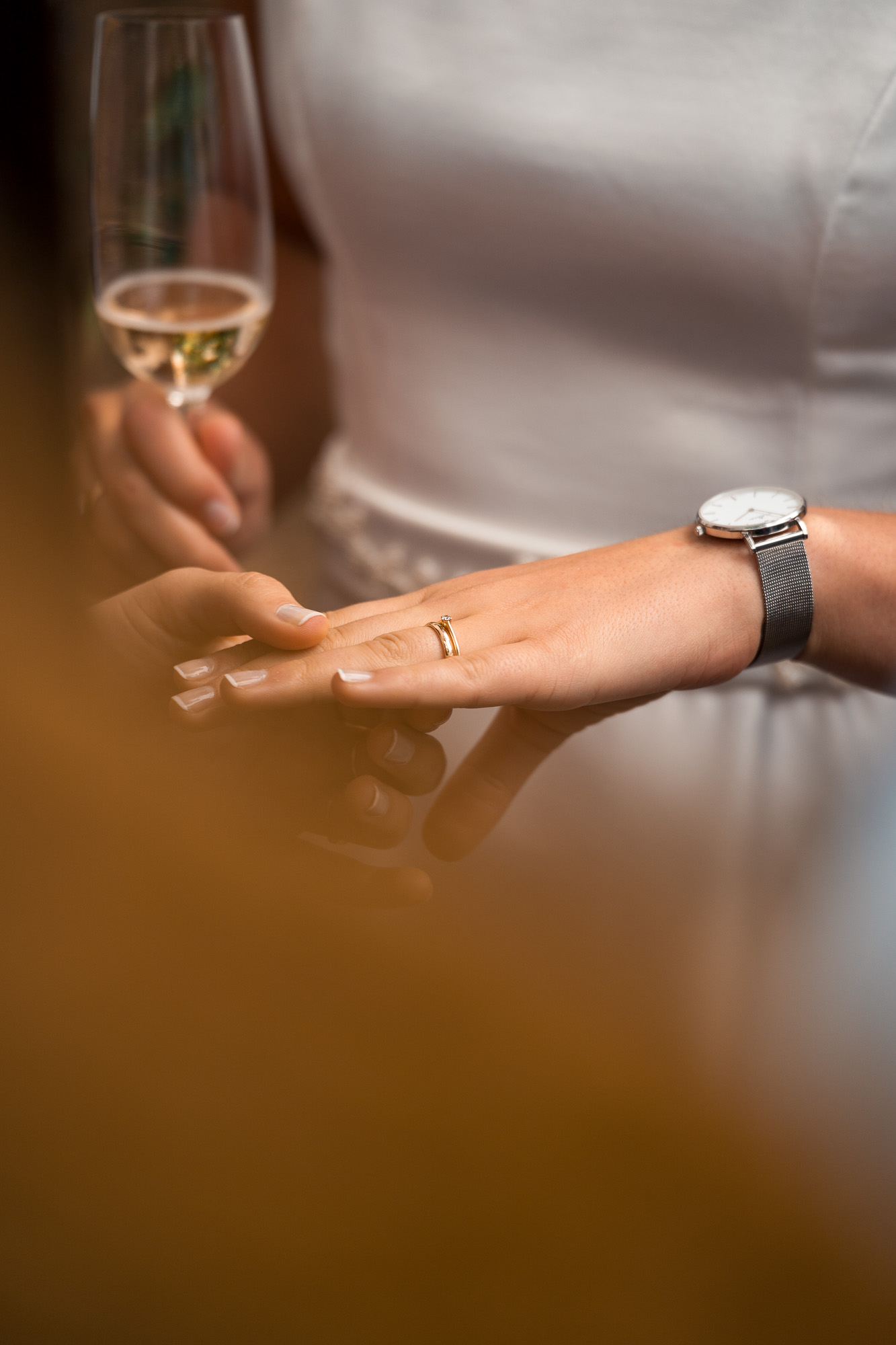 Lucia zeigt ihren Ehering, während sie ein Glas Sekt in der Hand hält